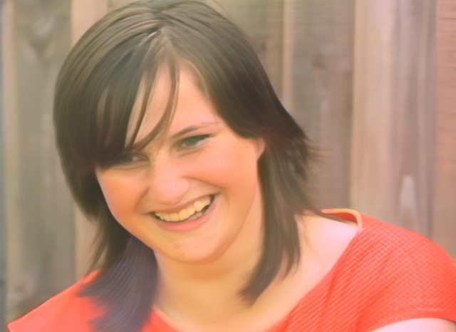 Teenage female with dark hair and wearing a red top