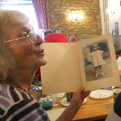 Older woman holding black and white photograph of child