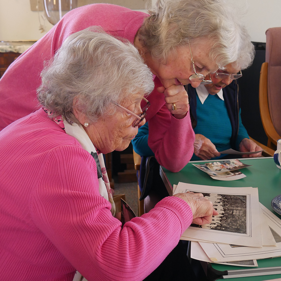 Three local residents taking part in Broadwindsor's Born and Bred community event, looking over old photographs